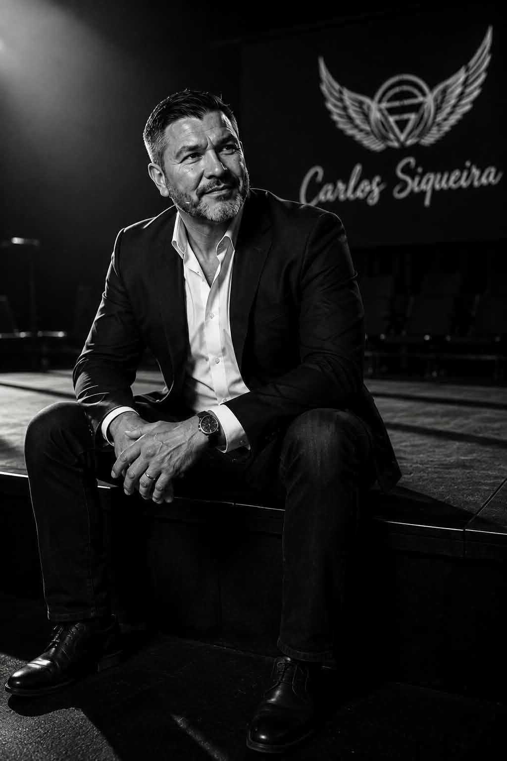 Carlos Siqueira seated on a stage